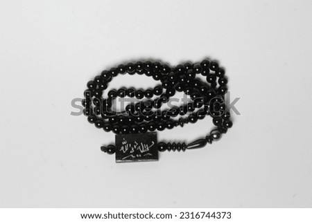 A tasbih that has Arabic writing, namely lailahaillallah and has a white background