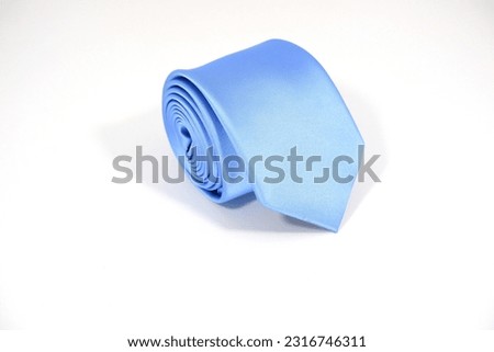 soft blue neck tie rolled isolated over white background close up view single object selective focused nobody copy space for texting and commercial usage  Royalty-Free Stock Photo #2316746311