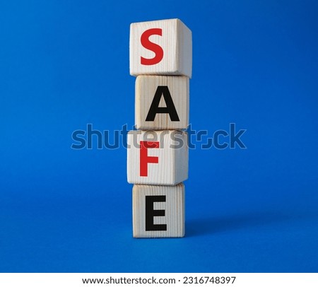 Safe symbol. Concept word Safe on wooden cubes. Beautiful blue background. Business and Safe concept. Copy space.