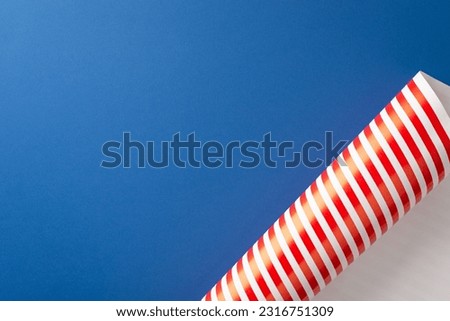 Get ready for Independence Day festivities. Aerial top view of specially designed wrapping paper for gifts on a blue background, featuring an empty space to add text or promotional content