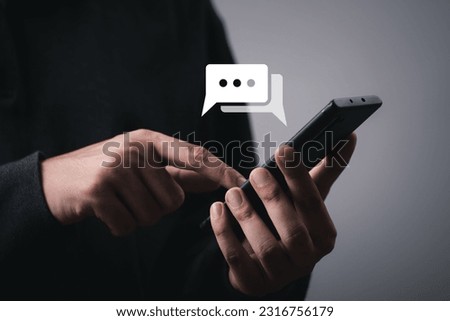 Man using smartphone typing Live chat chatting and social network concepts, chatting conversation working on mobile phone in chat box icons pop up. Social media marketing technology concept. Royalty-Free Stock Photo #2316756179