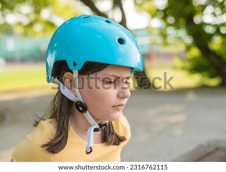 Portrait of a girl on roller skates, wearing a helmet and protective gear.