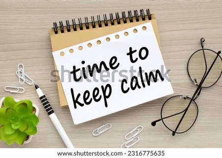 wood background words on notebook time to keep calm