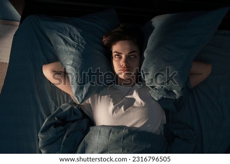 Annoyed woman suffering neighbour noise in the bedroom at night at home. She can't sleep at night. Noise and insomnia concept. Copy space Royalty-Free Stock Photo #2316796505