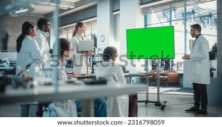 Group of Students Listening to Their Robotics Professor Who Uses Green Screen Monitor in a Laboratory. Team of Engineers Having a Meeting and Discussing Manufacturing Ideas, Using Technology