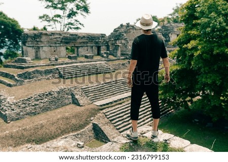 Hiker man with a hat looking at ancient Mayan ruins. High quality photo