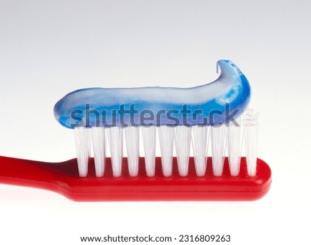 Toothbrush with blue toothpaste close-up on white background Royalty-Free Stock Photo #2316809263