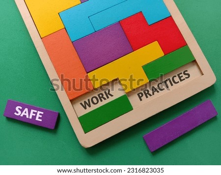 Colourful wooden puzzle with text SAFE, WORK and PRACTICES on green background. 