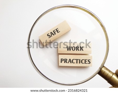 Magnifier glass on wooden blocks with text SAFE, WORK and PRACTICES isolated white background 
