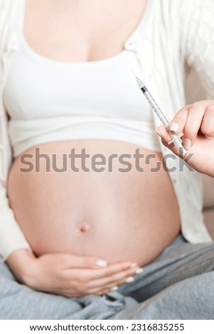 Pregnant woman with insulin syringe in home on bed. Pregnant diabetes concept.