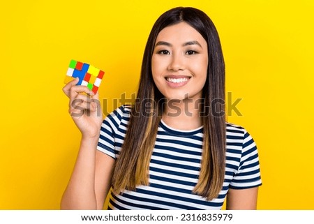 Photo of optimistic funny young chinese woman wear sailor t-shirt hold rubik cube playing logic toy isolated on yellow color background Royalty-Free Stock Photo #2316835979