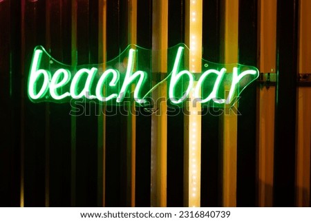 Neon signboard beach bar close-up.