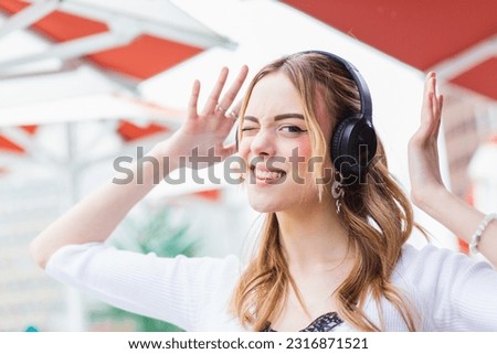 Smiling woman making gestures listening to music.