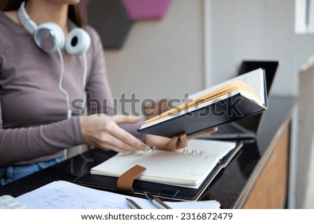 woman was sitting alone reviewing her lesson to understand and learn lesson before attending training and testing her knowledge of assigned book articles. Concepts of reading to learn and comprehend. Royalty-Free Stock Photo #2316872479