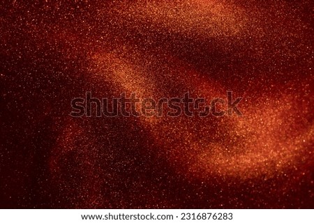 Amazing golden particles in red fluid. The shimmering overflow of gold particles in the red liquid. Beautiful shiny background. Royalty-Free Stock Photo #2316876283