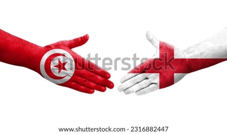Handshake between England and Tunisia flags painted on hands, isolated transparent image. Royalty-Free Stock Photo #2316882447