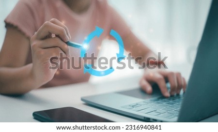 Women draw a recycling circle with arrows on a futuristic virtual interface screen. Business or economic stagnation or recycle concept. Royalty-Free Stock Photo #2316940841