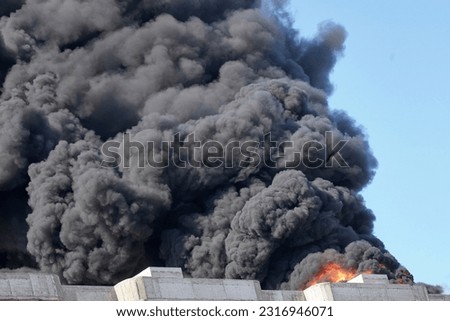 Huge clouds of smoke against the sky, a large fire at a construction site