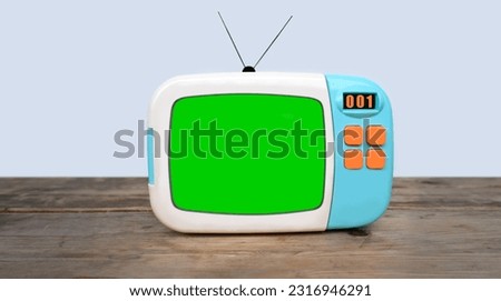 old blue plastic retro TV with buttons with blank green screen for designer, video film stands in light room on vintage wooden table, concept of cozy house 1960-1970, stylish mockup