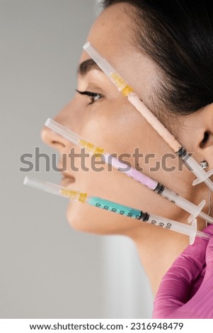 Girl with vitamin cocktail syringes for injections. Mesotherapy injections of vitamins, enzymes, hormones, and plant extracts to rejuvenate and tighten skin and remove excess fat Royalty-Free Stock Photo #2316948479