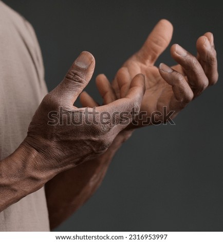 black man praying to god with hands together on dark background stock photo	