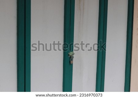 The doors of shophouses and shops are made of planks that are still locked