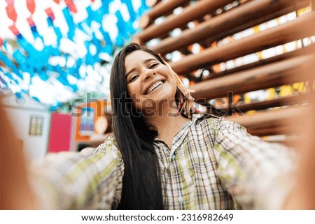 Woman wearing typical clothes for Festa Junina taking a selfie