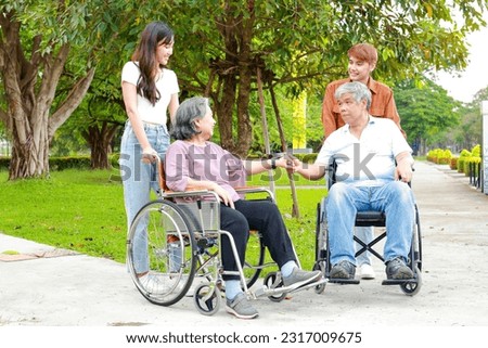 Staff or caregivers take elderly people in wheelchairs to breathe fresh air at an outdoor garden to meet and chat with friends. Elderly health center