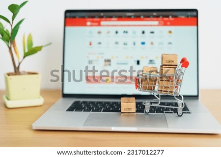 Boxes with shopping cart on a laptop computer. online shopping, Marketplace platform website, technology, ecommerce, shipping delivery, logistics and online payment concepts Royalty-Free Stock Photo #2317012277