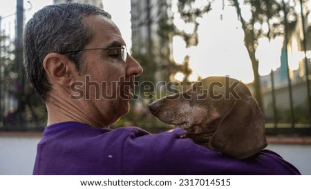 a man in a purple shirt with his pet dogs