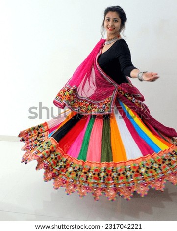 A woman wearing Chaniya choli and the choli is rotating in the air when woman takes round. Traditional attire used with playing Garba and dandiya during navratri Royalty-Free Stock Photo #2317042221
