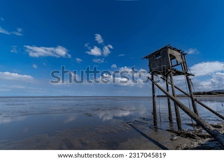 broken hut for net fishing and a tidal flat beach in Saga prefecture, JAPAN. Royalty-Free Stock Photo #2317045819