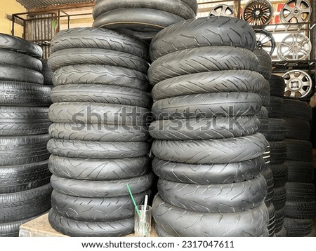 Many stacks of car and motorcycle tire with various size in auto store for sale.