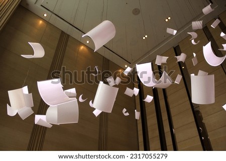A hotel lobby decoration made to resemble fluttering papers. Royalty-Free Stock Photo #2317055279