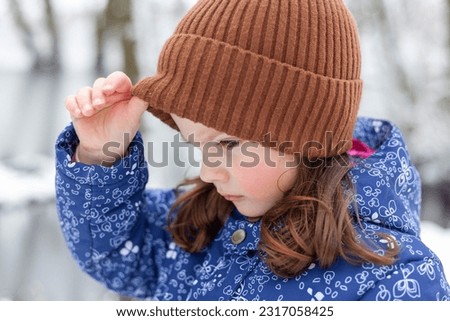 Portrait of a cute little girl in winter park. Selective focus.