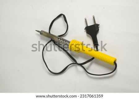 Solder iron or soft solder is a metal alloy that melts easily, and is used as a filler metal to join two metal materials. It has a yellow handle and a white background. Royalty-Free Stock Photo #2317061359