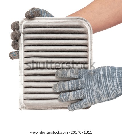 Hands of a worker holding a car air filter isolated on white background.