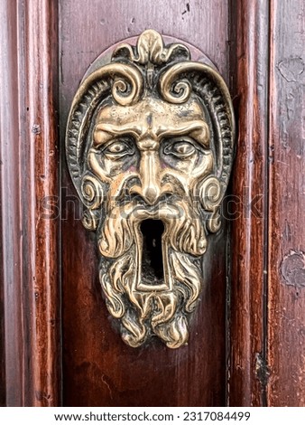 historic brass door latch with human face. High quality photo
