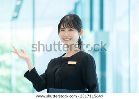 Hotel staff showing guests around Royalty-Free Stock Photo #2317115649