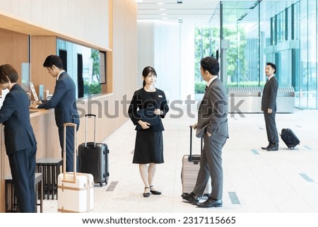 Hotel staff showing guests around Royalty-Free Stock Photo #2317115665