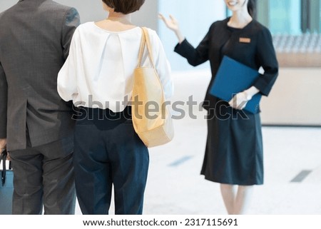Hotel staff showing guests around Royalty-Free Stock Photo #2317115691