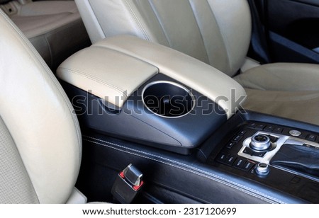 Car inside, cup holders and armrest, beige leather seats, automatic transmission close up. Cup holders in the car. Lux car beige leather interior. Royalty-Free Stock Photo #2317120699