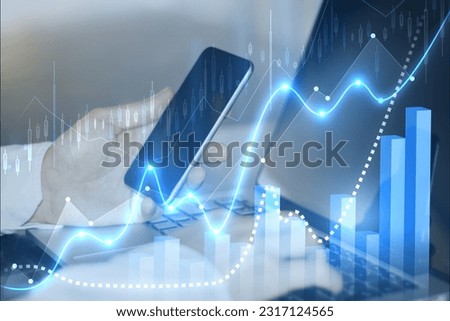 Side view of businessmen hands using laptop and cellphone with glowing blue candlestick business chart on blurry background. Trade, finance and market concept. Double exposure