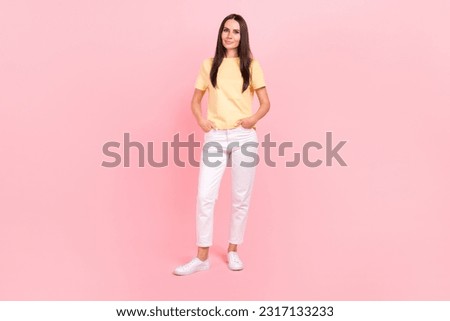 Full length photo of cute sweet woman dressed yellow t-shirt hands pockets walking isolated pink color background