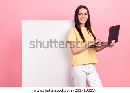 Photo of sweet pretty woman dressed yellow t-shirt texting modern gadget poster empty space isolated pink color background