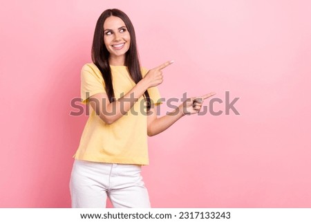 Photo attractive promoter woman direct fingers empty space banner ads information wear yellow shirt isolated pink color background