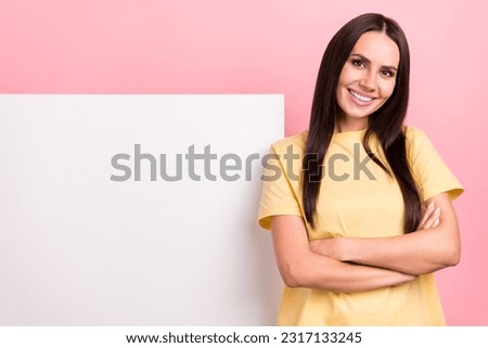 Photo of adorable confident woman dressed yellow t-shirt arms crossed poster empty space isolated pink color background