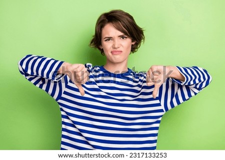 Photo portrait of young dissatisfied angry woman refused two thumbs down bad mood dislike strict unhappy isolated on green color background Royalty-Free Stock Photo #2317133253