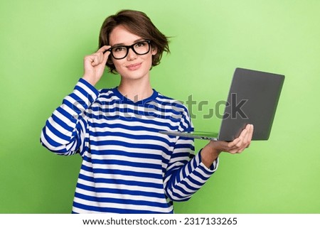 Photo portrait of young satisfied cute working lady wear glasses hold laptop working remote assistant isolated on green color background