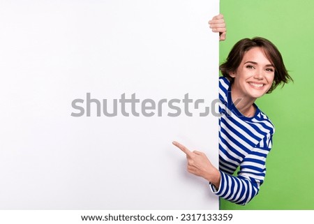 Photo of young charming girl promoter pointing finger big empty space placard mockup advertisement promo isolated on green color background